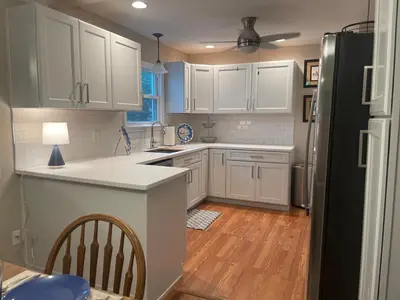 a kitchen with white cabinets and a refrigerator at Newly renovated 3-bedroom lakeside home in Euclid