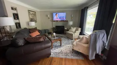 a living room with a couch and chairs and a tv at Newly renovated 3-bedroom lakeside home in Euclid