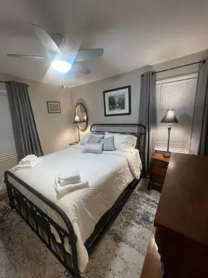 a bedroom with a bed with a ceiling fan at Newly renovated 3-bedroom lakeside home in Euclid