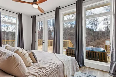 a bedroom with a bed and large windows at Primrose - Cave Run Lake OR Red River Gorge KY in Wellington
