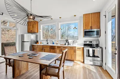 a kitchen with wooden cabinets and a table with chairs at Primrose - Cave Run Lake OR Red River Gorge KY in Wellington