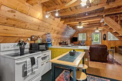 a kitchen with a stove and a table in it at Sugar Shack - Cave Run Lake OR Red River Gorge KY in Bangor