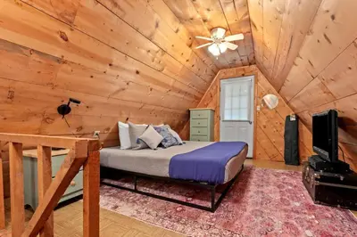 a bedroom with a bed in a log cabin at Sugar Shack - Cave Run Lake OR Red River Gorge KY in Bangor
