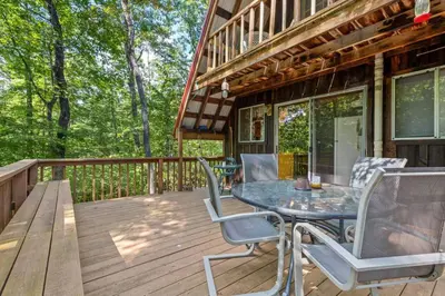 a wooden deck with a table and chairs on it at Sugar Shack - Cave Run Lake OR Red River Gorge KY in Bangor
