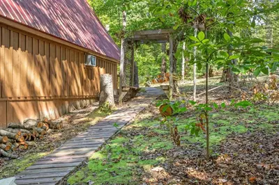 a wooden path next to a house with a tree at Sugar Shack - Cave Run Lake OR Red River Gorge KY in Bangor