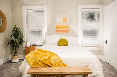 a bedroom with a white bed with a yellow blanket on it at Classic Hilltop 3br home on Eastern ready for you! in Cincinnati