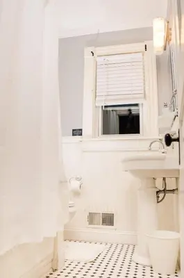 a white bathroom with a sink and a mirror at Classic Hilltop 3br home on Eastern ready for you! in Cincinnati