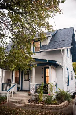 a white house with a black roof at Country cottage in Cheviot! in Cincinnati