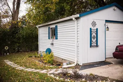 a small white shed with a blue roof at Country cottage in Cheviot! in Cincinnati