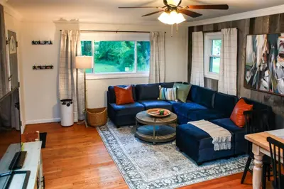 a living room with a blue couch and a table at WiFi & Pets - Alice Rocks - Cave Run Lake & RRG KY in Frenchburg