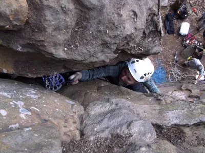 a man laying on rocks with a helmet on at WiFi & Pets - Alice Rocks - Cave Run Lake & RRG KY in Frenchburg