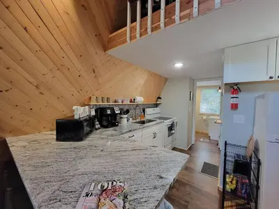 a kitchen with a marble counter top and wooden walls at A Frame of Mind - near Red River Gorge KY in Jeffersonville