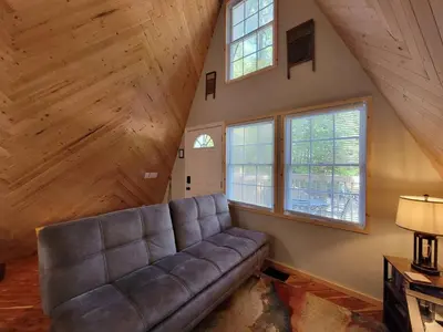 a living room with a couch and two windows at A Frame of Mind - near Red River Gorge KY in Jeffersonville