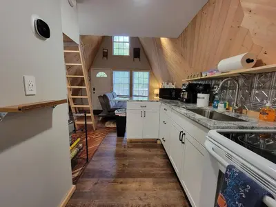 a kitchen with white cabinets and a wooden ceiling at A Frame of Mind - near Red River Gorge KY in Jeffersonville
