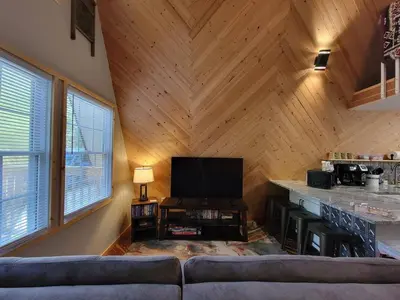 a living room with a couch and a flat screen tv at A Frame of Mind - near Red River Gorge KY in Jeffersonville