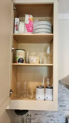 a cupboard with dishes and other items in it at WiFi Firepit Fishing Pond - FarmView in Hazel Green