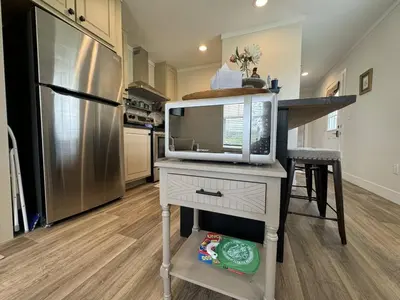 a kitchen with a tv on a table with a refrigerator at WiFi Firepit Fishing Pond - FarmView in Hazel Green