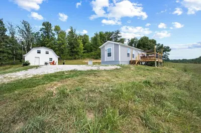 a house on the side of a grassy field at WiFi Firepit Fishing Pond - FarmView in Hazel Green