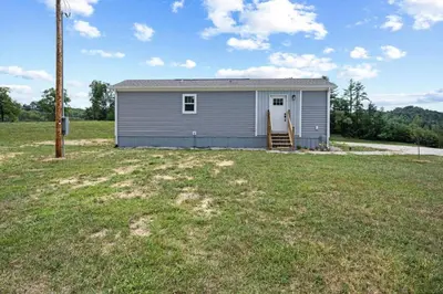a small house in a field with a yard at WiFi Firepit Fishing Pond - FarmView in Hazel Green