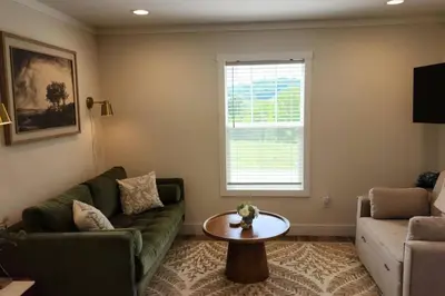 a living room with a couch and a table at WiFi Firepit Fishing Pond - FarmView in Hazel Green