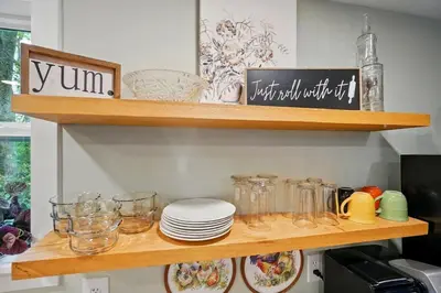 a wooden shelf with plates and glasses on it at Carriage House Retreat 1 in Milford