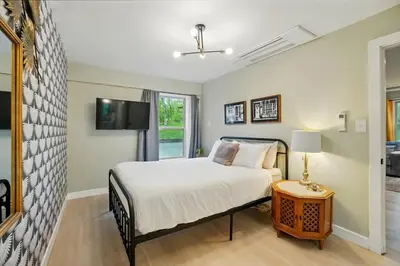 a bedroom with a bed and a tv on a wall at Carriage House Retreat 1 in Milford