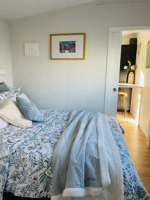 a bedroom with a bed with a blue and white blanket at The Travellers Tiny Hideaway in Cincinnati