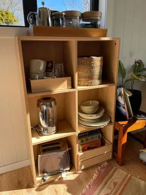 a wooden shelf with dishes and other items on it at The Travellers Tiny Hideaway in Cincinnati