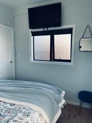a bedroom with a bed and a tv on the wall at The Travellers Tiny Hideaway in Cincinnati