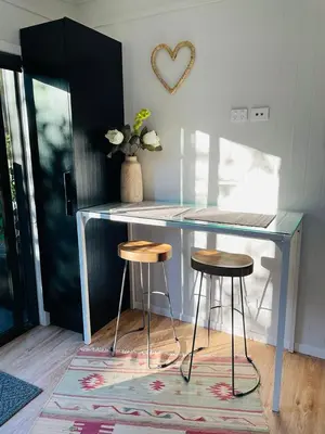 a counter with two stools in a room with a table at The Travellers Tiny Hideaway in Cincinnati