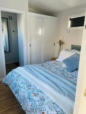 a bedroom with a bed with a blue blanket at The Travellers Tiny Hideaway in Cincinnati