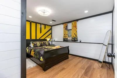 a bedroom with a bed and a yellow and white wall at Spring Lovers Retreat Sauna, Hot Tub & Firepit in South Bloomingville