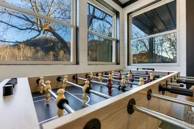 a billiard room with a table and several windows at Spring Lovers Retreat Sauna, Hot Tub & Firepit in South Bloomingville
