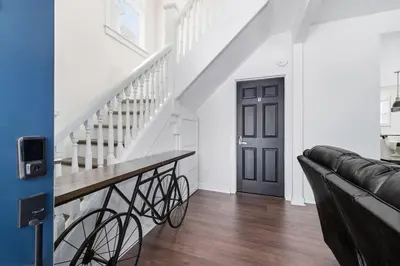 a living room with a staircase and a black door at Contemporary Private En-Suite - Steps to Cleveland Clinic in Cleveland