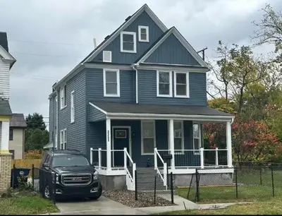 a blue house with a car parked in front of it at Contemporary Private En-Suite - Steps to Cleveland Clinic in Cleveland