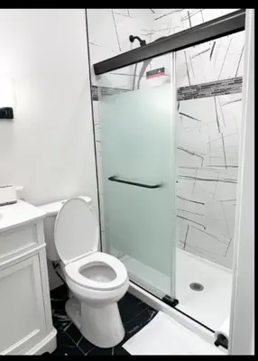 a bathroom with a toilet and a glass shower at Contemporary Private En-Suite - Steps to Cleveland Clinic in Cleveland