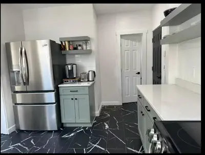 a kitchen with a stainless steel refrigerator and black tile floors at Contemporary Private En-Suite - Steps to Cleveland Clinic in Cleveland