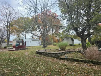 a yard with trees and houses and a fence at Gather at the Cape in Youngstown