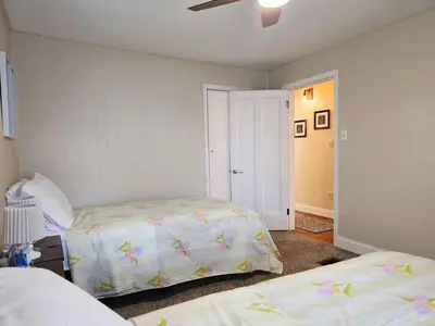 a bedroom with two beds and a ceiling fan at Gather at the Cape in Youngstown