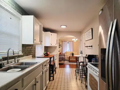 a kitchen with white cabinets and a table and chairs at Gather at the Cape in Youngstown