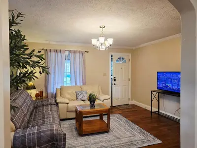 a living room with a couch and a tv at Gather at the Cape in Youngstown