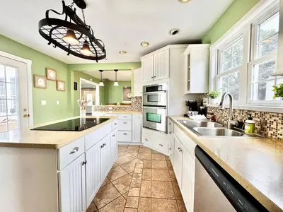 a kitchen with white cabinets and green walls at The Porch in Marion