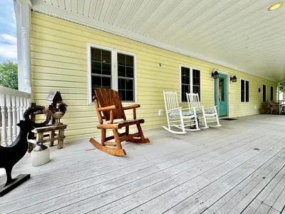 a porch with rocking chairs on a yellow house at The Porch in Marion