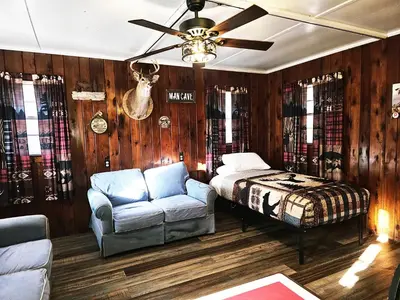 a bedroom with a bed and a chair and a ceiling fan at The Huntsmen in Hillsboro