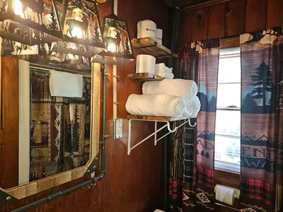 a bathroom with a mirror and a shelf with towels at The Huntsmen in Hillsboro