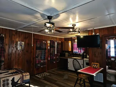 a living room with a ceiling fan and a kitchen at The Huntsmen in Hillsboro