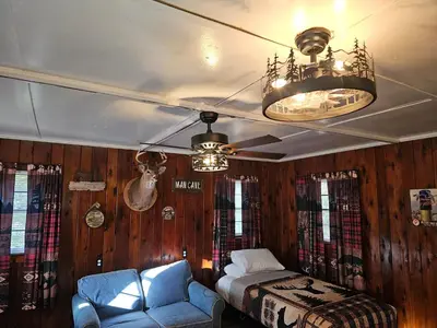 a bedroom with a bed and a couch and a ceiling fan at The Huntsmen in Hillsboro