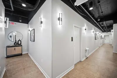 a hallway of a room with white walls and wood floors at The 333 Suites 201 - Stay for 6 in Cincinnati