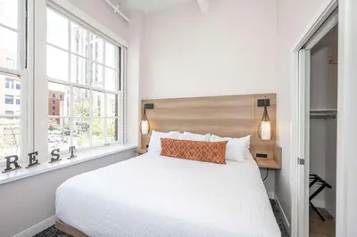 a bedroom with a white bed and a window at The 333 Suites 201 - Stay for 6 in Cincinnati