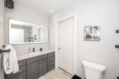 a bathroom with a sink and a toilet and a mirror at The 333 Suites 201 - Stay for 6 in Cincinnati